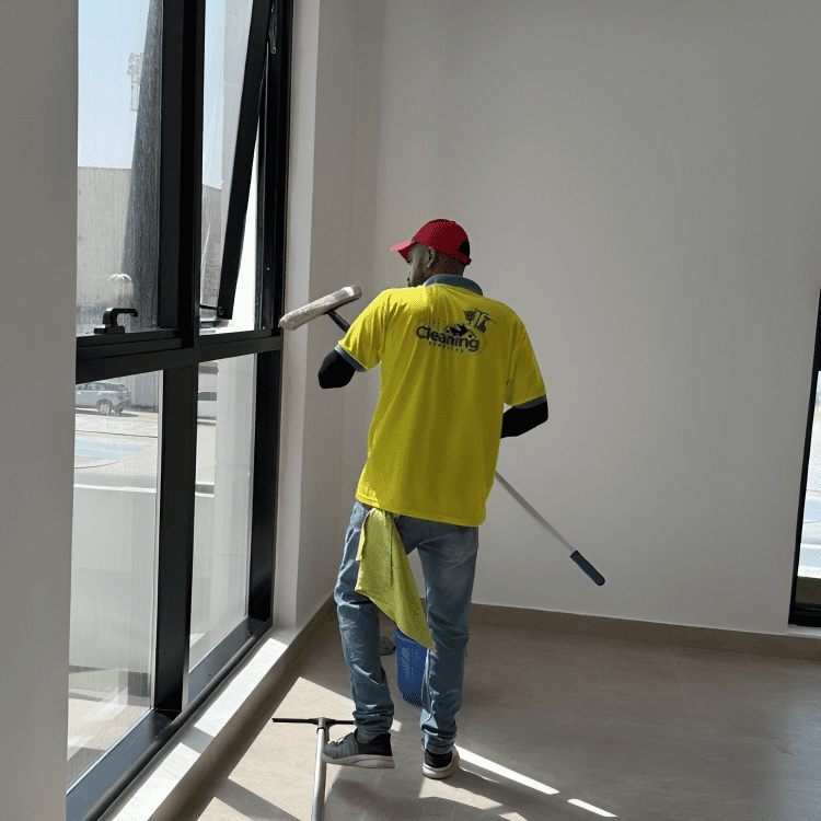 HiFi Cleaning expert wiping tall window panels during high-precision glass cleaning service.